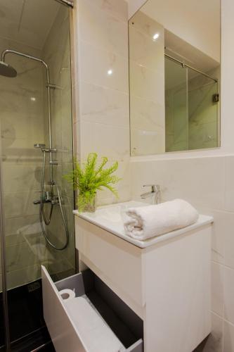 a white bathroom with a sink and a shower at Accra Luxury Apartments at Embassy Gardens in Accra