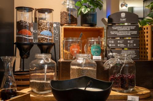 a table with glass jars of seeds and other items at Hotel Docklands Antwerpen in Antwerp