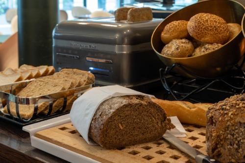 a table topped with bread and pastries on a counter at Hotel Docklands Antwerpen in Antwerp