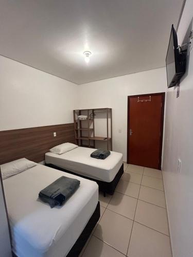 a room with two beds and a television in it at Hotel Jardim Emilia Sorocaba in Sorocaba