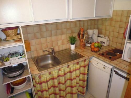 une cuisine avec un évier et un plan de travail dans l'établissement Appartement T2 cabine 6 personnes - Ski - Balcon sud - FR-1-404-64, à La Mongie