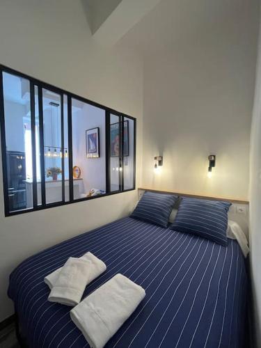 - une chambre avec un grand lit bleu et deux oreillers dans l'établissement Studio Central Ancien Hotel Salomon XVIe siècle, à Marseille
