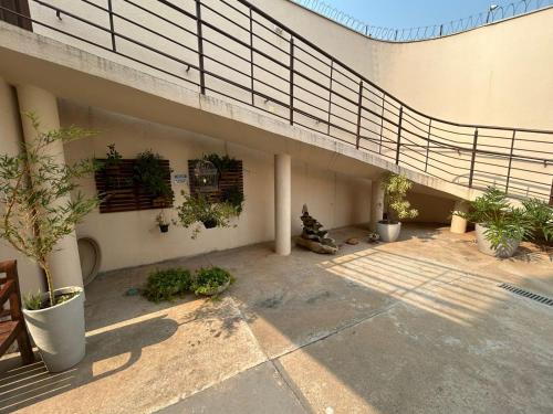 a patio with potted plants on the side of a building at Hotel Jardim Emilia Sorocaba in Sorocaba
