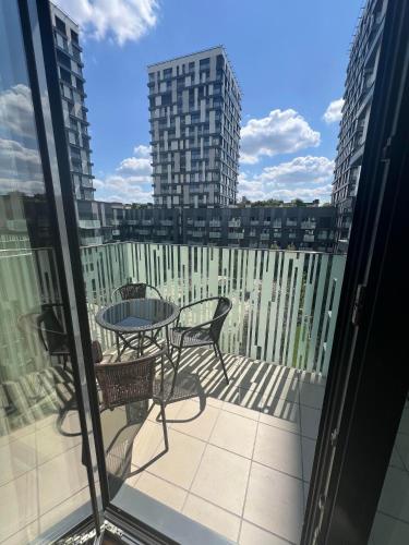 a patio with a table and chairs on a balcony at Apartments in Residence Garden Towers in Prague