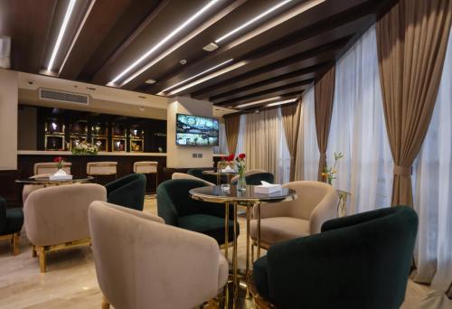a waiting room with chairs and tables and a tv at Cairo Taj Hotels & Suites- Mohandessin in Cairo