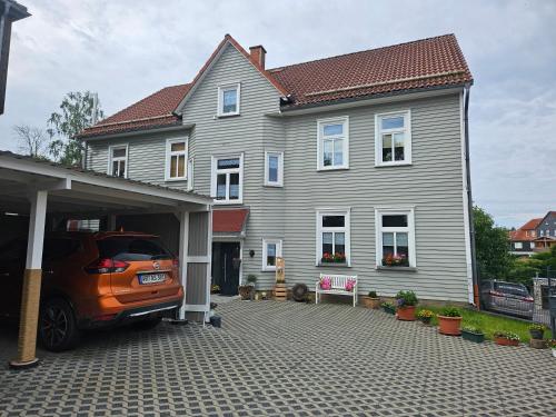 an orange car parked in front of a house at Zur-kleinen-Auszeit in Benneckenstein