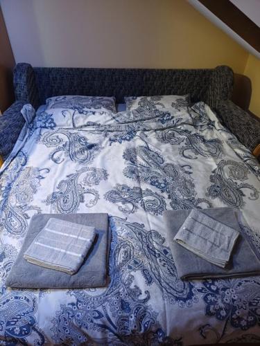 een blauw en wit bed met twee boeken erop bij NIKA apartman stan na dan in Šabac