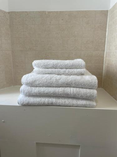 three towels are stacked on a shelf in a bathroom at Chelmsford City - 17th Century Apartment in Chelmsford