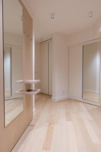 an empty room with white walls and a large mirror at Apartmani Zepterme by CENTRAL in Vrnjačka Banja