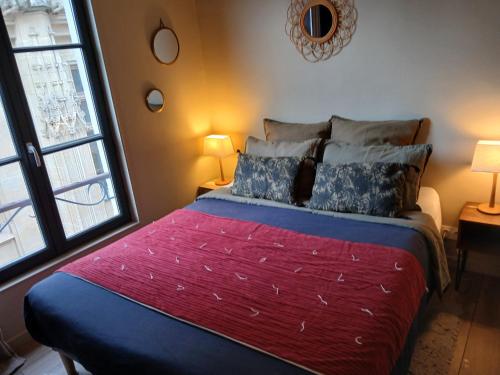 een slaapkamer met een bed met een groot raam bij L'Echiquier de Normandie confort cosy et vue premium in Rouen