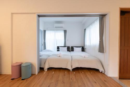 a bedroom with two beds and a large mirror at Villa Blue Terasu 宮古島 in Matsubara