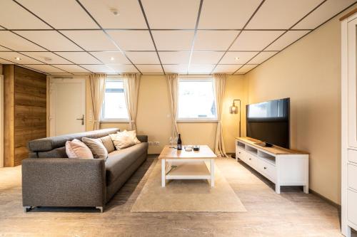 a living room with a couch and a tv at Apart Hotel Lang in Altenahr