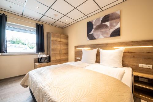 a bedroom with a bed and a window at Apart Hotel Lang in Altenahr