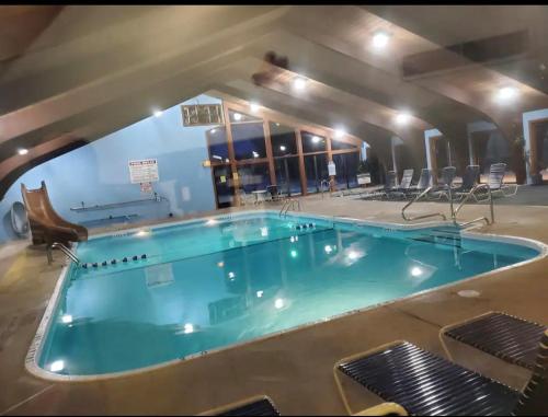 a large swimming pool in a building with chairs at School Section Cottage Lake Access in Mecosta