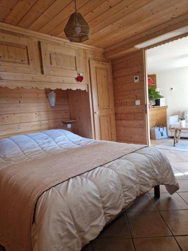 Cette chambre en bois comprend un grand lit. dans l'établissement Pierre de Famille, à Manigod