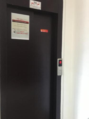 a black refrigerator with two signs on the side of it at Résidence les deux palmiers Temara Rabat in Temara