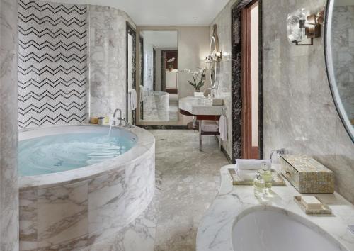 a large bathroom with a tub and a sink at Mandarin Oriental, Doha in Doha
