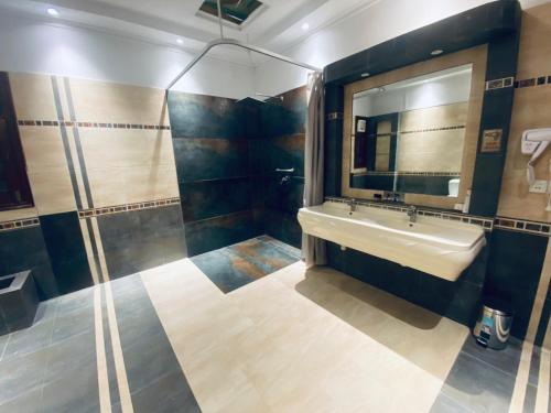 a bathroom with a sink and a mirror at Sunset BnB Creek in Karachi
