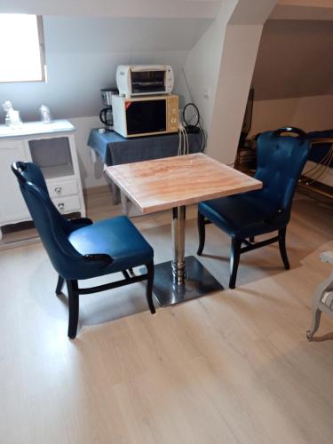 a table and chairs in a room with a microwave at studios les Hortensias in Lillers