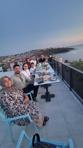 a group of people sitting at a table on a balcony at Ugem in Seferihisar