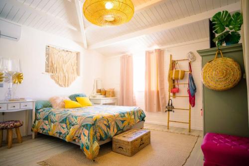 a bedroom with a bed and a desk in it at Villa Le Ropert'Zen in Saint-François