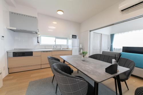 a kitchen and dining room with a table and chairs at Villa Blue Terasu 宮古島 in Matsubara