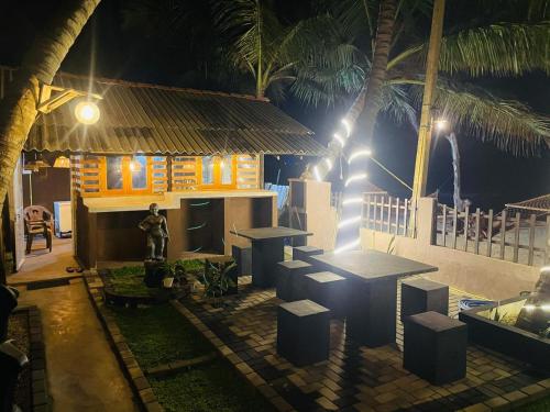 a patio with a table and a house at night at Winston Sea Front Villa in Negombo