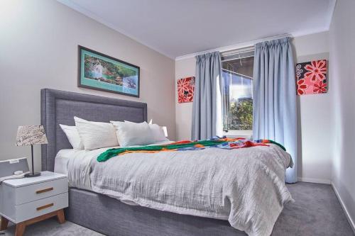 a bedroom with a large bed and a window at 1BR eco apartment with tennis court and carpark in Melbourne