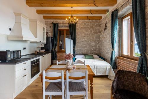 Una cocina con una mesa y una cama en una habitación. en Obala apartman, en Biograd na Moru