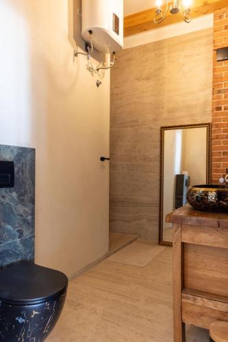 a bathroom with a black toilet and a sink at Obala apartman in Biograd na Moru