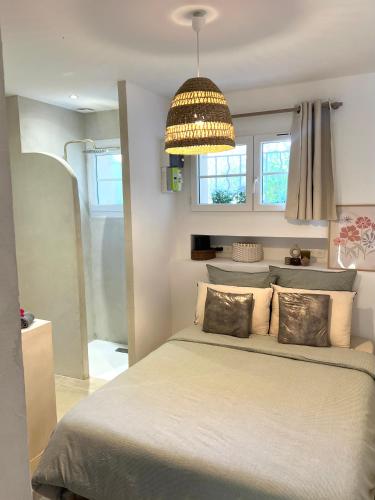 - une chambre avec un grand lit et un lustre dans l'établissement Appartement avec Jardin et proche plage, à Toulon
