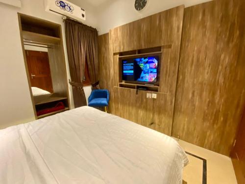 a hotel room with a bed and a tv at Sunset BnB Creek in Karachi