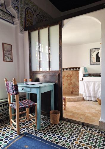 a bathroom with a table and a bath tub at Dar El Bali in Fès