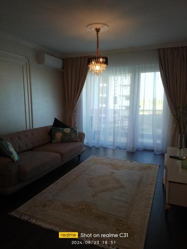 a living room with a couch and a chandelier at Avangarde de Lux Apartment in Seleuş