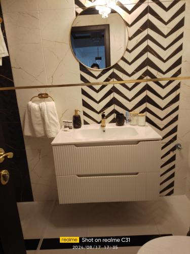 a bathroom with a sink and a mirror at Avangarde de Lux Apartment in Seleuş
