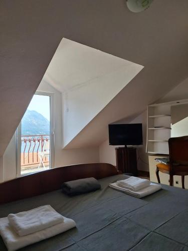 a bedroom with a bed with a large window at Dobrota Comfort in Kotor
