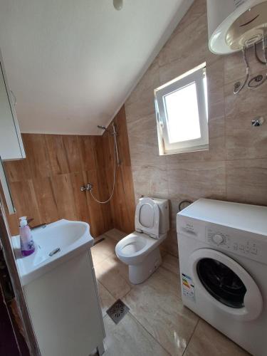 a bathroom with a toilet and a washing machine at Dobrota Comfort in Kotor