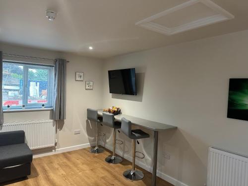 a living room with a table and a tv at Cedarwood B&B in Felton