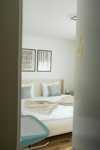 a bedroom with a bed with three pictures on the wall at NH 6 Interlaken-Luzern I Lake I Mountain I connect in Sachseln