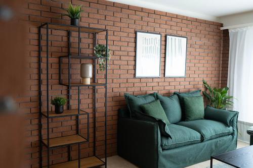 a living room with a couch and a brick wall at NH 6 Interlaken-Luzern I Lake I Mountain I connect in Sachseln