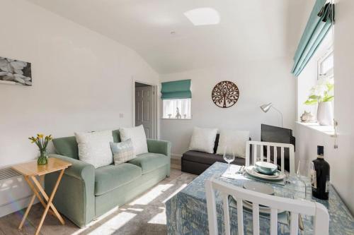 a living room with a green couch and a table at Ty Cwtch in Nottage