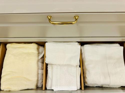 un tiroir avec trois serviettes blanches dans l'établissement Appt rénové proche Montmartre Gare du Nord et EST, à Paris