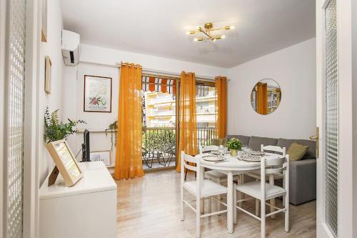une salle à manger et un salon avec une table et des chaises dans l'établissement Colonel hébert deux pièces climatisé, à Menton
