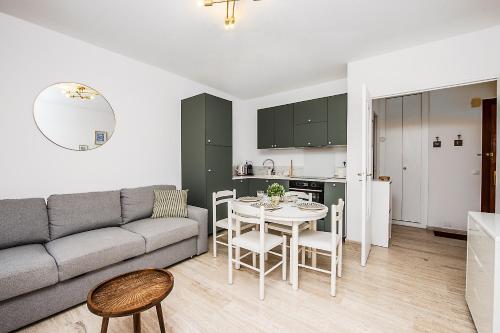 un salon avec un canapé et une table et une cuisine dans l'établissement Colonel hébert deux pièces climatisé, à Menton