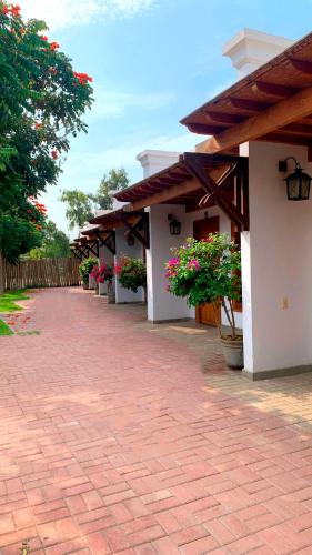 a building with potted plants and a brick sidewalk at Casa Hacienda San Jose in Chincha Alta