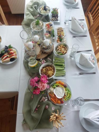 a table with many plates of food on it at Jaun-Ieviņas in Rauna