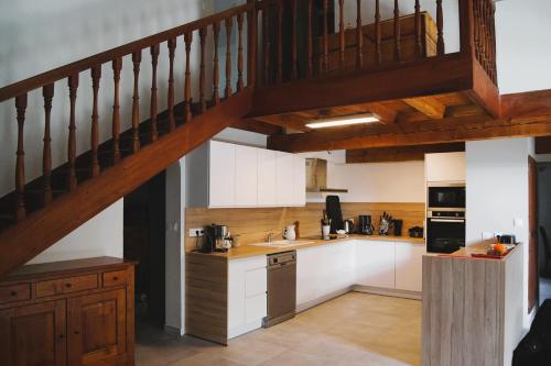 une cuisine avec des placards blancs et un escalier en bois dans l'établissement Grande Villa Rénovée à 600 m de la Plage, à Solaro