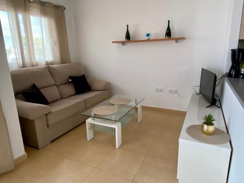 a living room with a couch and a table at Condado de Alhama, Jardin 11 in Alhama de Murcia