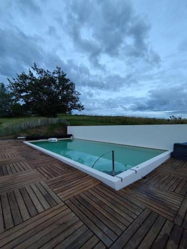 - une piscine en verre sur une terrasse en bois dans l'établissement Gîte Les Petits Belézins, à Saint-Amour