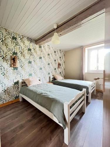 une chambre avec deux lits dans une pièce dans l'établissement Gîte Les Petits Belézins, à Saint-Amour